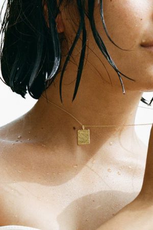 woman wearing the Tia Necklace in gold by the sustainable jewelry brand Agapé Studio, curated by Morsel Store