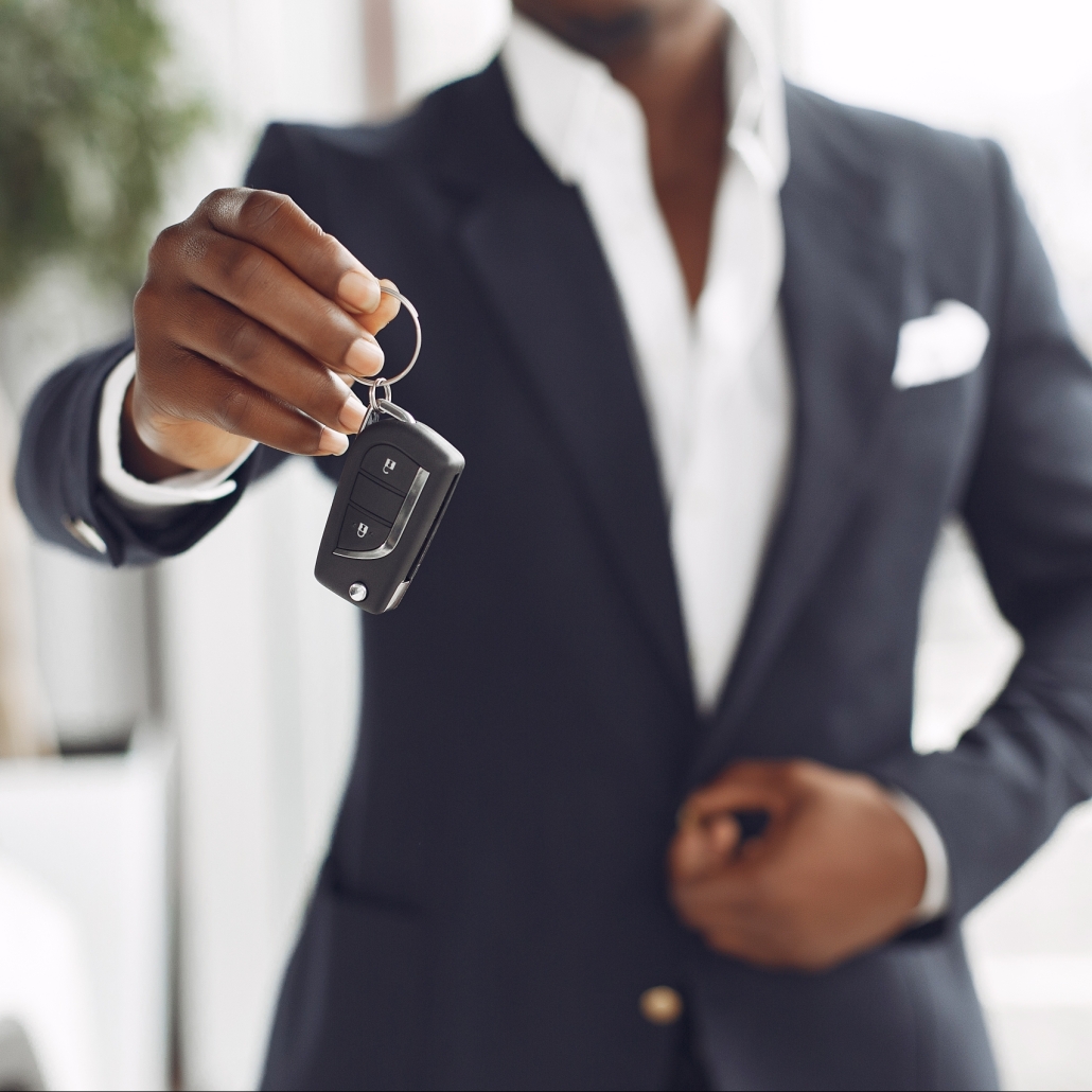 Handsome and elegant black man in a car salon