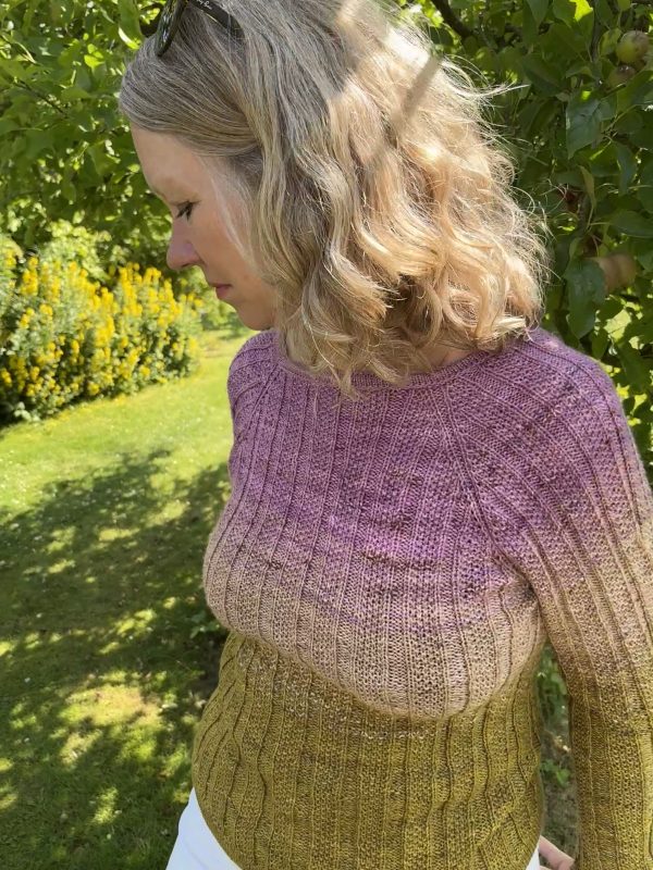 Kvinde i have iklædt en strikket bluse, der changerer i tre farver