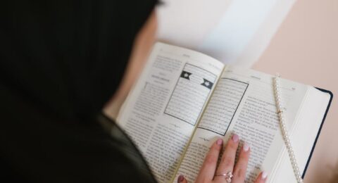 person in black hijab holding white printer paper