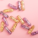 pile of sparkling drug capsules scattered on pink surface