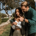 man in green dress shirt holding woman in black dress