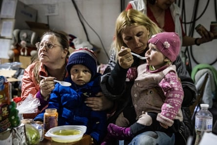 People eat and drink at a food tent in Zaporizhzhia catering for evacuees from Mariupol, 8 May 2022.