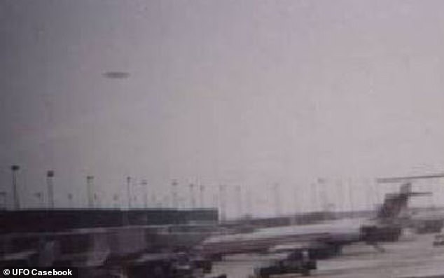 At about 4:14pm on November 7 2006, a ramp employee at O'Hare International Airport in Chicago, USA spotted a metallic, saucer-shaped craft hovering in the sky. Pictured: An image of the UFO taken on an airport employee's phone