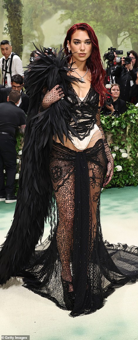 Dua showcased her flat stomach with the low-cut lace skirt, paired a white corset that had a black lace overlay