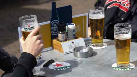 Customers drink Heineken beer at an outdoor terrace