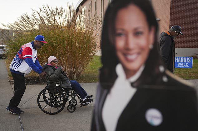 Liza Fortt, 74, center, accompanied by her son Timothy Walker, left, and husband Willie Fortt moves in line to cast her ballot for Democratic presidential nominee Vice President Kamala Harris at a polling place at Scranton High School in Scranton, Pa., on Election Day