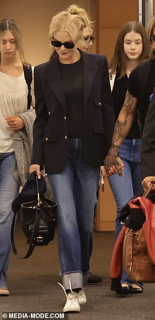 For her travels, she cut a stylish figure in a black T-shirt and denim straight leg jeans