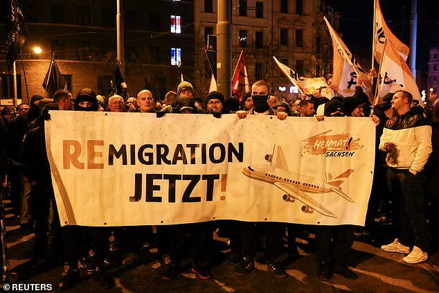 People hold a sign reading "Remigration now!" during a protest after a car drove into a crowd at a Christmas market, in Magdeburg, Germany December 21