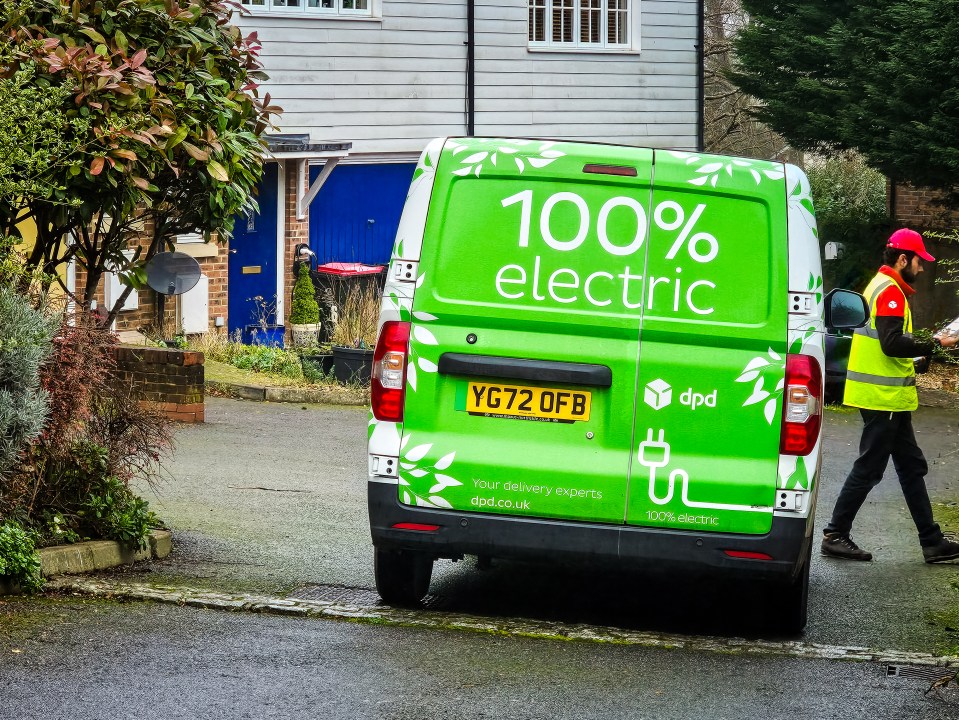 A DPD driver making a delivery with an electric van.