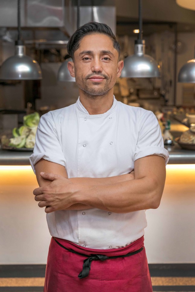 Eran Tibi standing in front of restaurant counter with his arms folded