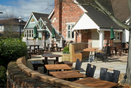 Harvester pub patio with tables and chairs.