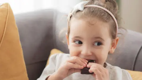 Getty Images Little girl eating a piece of chocolate