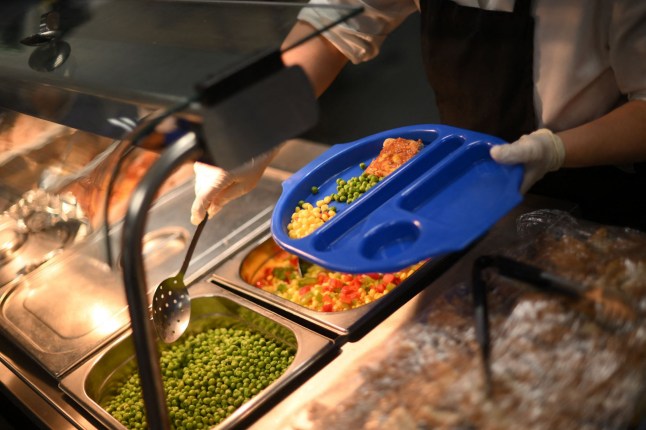 A school canteen chef serves children.