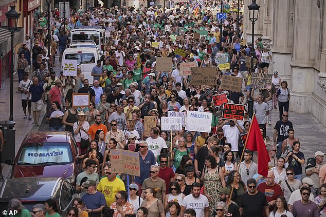 Pictured: People march during a protest against over tourism in the Balearic island of Mallorca, Spain, Sunday, June 15, 2025