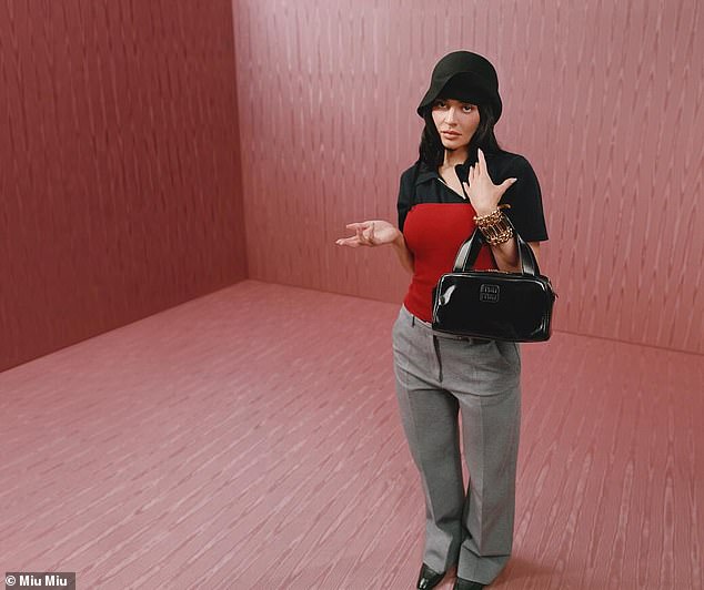 Jenner also slipped into light gray trousers as well as a black shirt that was layered with a red corset-styled piece on top
