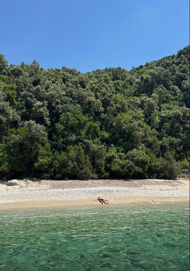 In one of the pictures that she shared, Kylie showed her fans a glimpse at the scenic shore - and a man could be seen sprawled out on the sand far in the distance