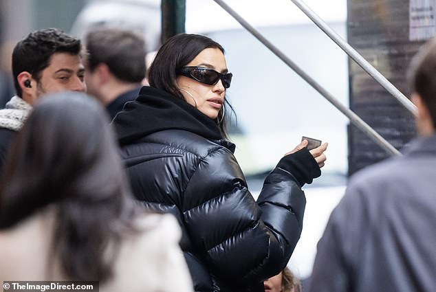 Irina looked gorgeous in a black Nike puffy jacket over a black hoodie and bottoms, adding hoop earrings and small framed sunglasses