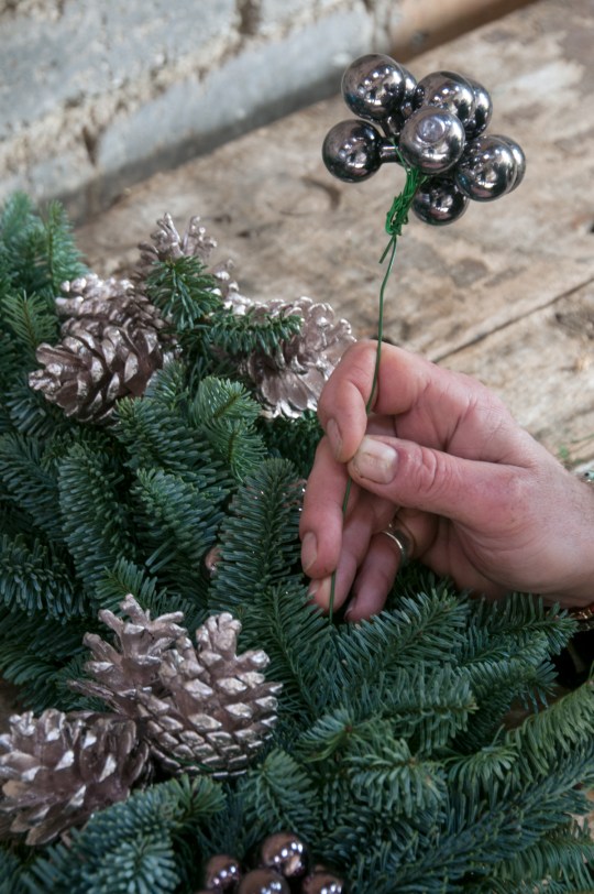 Baubles being clustered using stub wire and attached to the front of the wreath. 