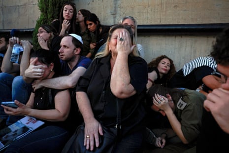 Friends and family take cover as rocket sirens sound during the funeral of Sagiv Ben Zvi, 24, killed after the attack by Hamas gunmen from the Gaza Strip as he attended the Nova festival in southern Israel, in Holon, Israel, 26 October