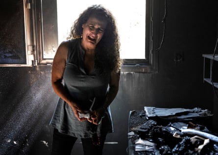 Hadas Kalderon – whose children Erez and Sahar and their father, Ofir, were kidnapped, while her mother and niece were killed, during the attack by Hamas gunmen on Nir Oz kibbutz – cries in the burned-out remains of her mother’s home, 30 October