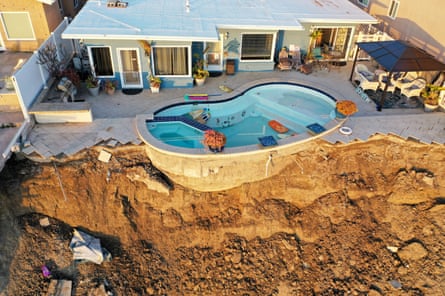 A pool at the edge of a hillside landslide, which caused four ocean view apartment buildings to be evacuated and shuttered, 16 March in San Clemente, California, after weeks of rains loosened the soil in Orange County which tumbled down near railway tracks that run next to the beach below 