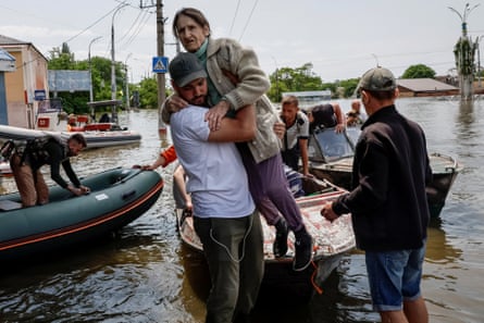 Volunteers evacuate residents from a flooded area after the Nova Kakhovka dam breached, amid Russia’s attack on Ukraine, in Kherson, 8 June 