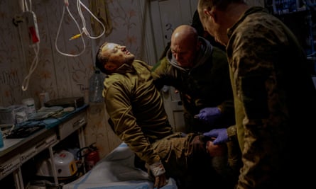 Medics of the 5th Separate Assault Brigade help injured Ukrainian serviceman Mykhailo, 42, inside a medical stabilisation point, near the frontline in the Donetsk region, 9 November 