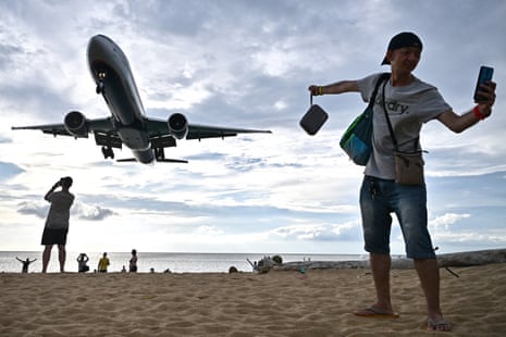 A tourist taking a selfie on the Mai Khao beach as a plane lands at Phuket international airport in the southern Thai island of Phuket. Thailand, Cambodia and Vietnam are throwing up new airports and terminals, and a new airline is set to launch next year all banking on an expected boom in air travel in south-east Asia, fuelled by Chinese and Indian tourists 
