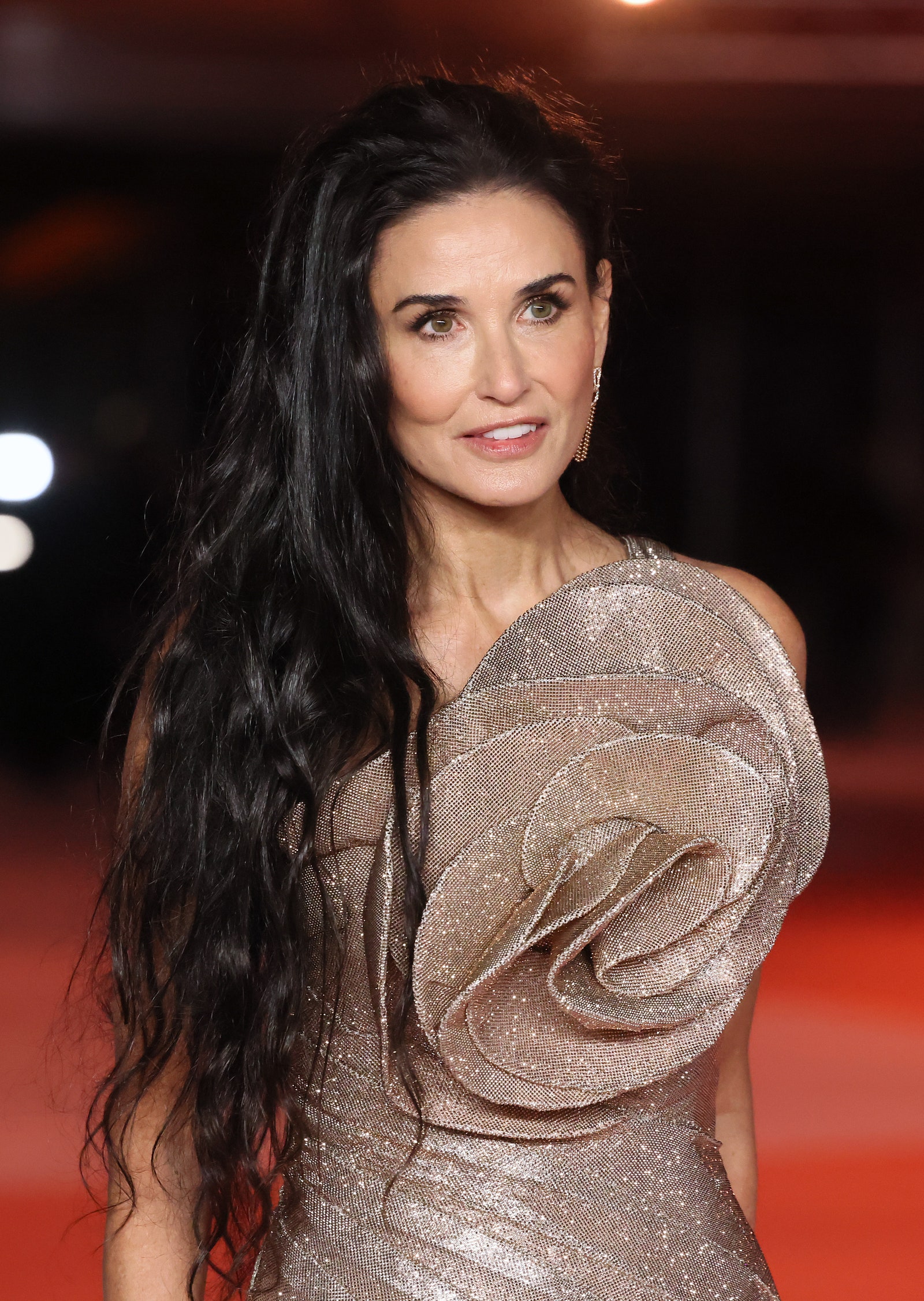 Demi Moore poses in a sequined rosette gown