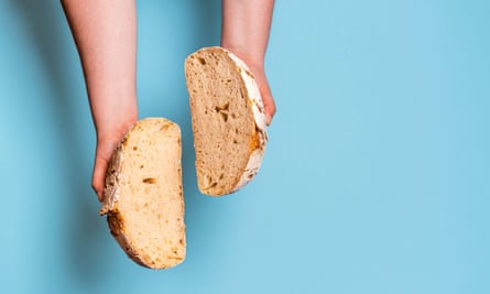 a loaf of bread chopped in half in a person's hands
