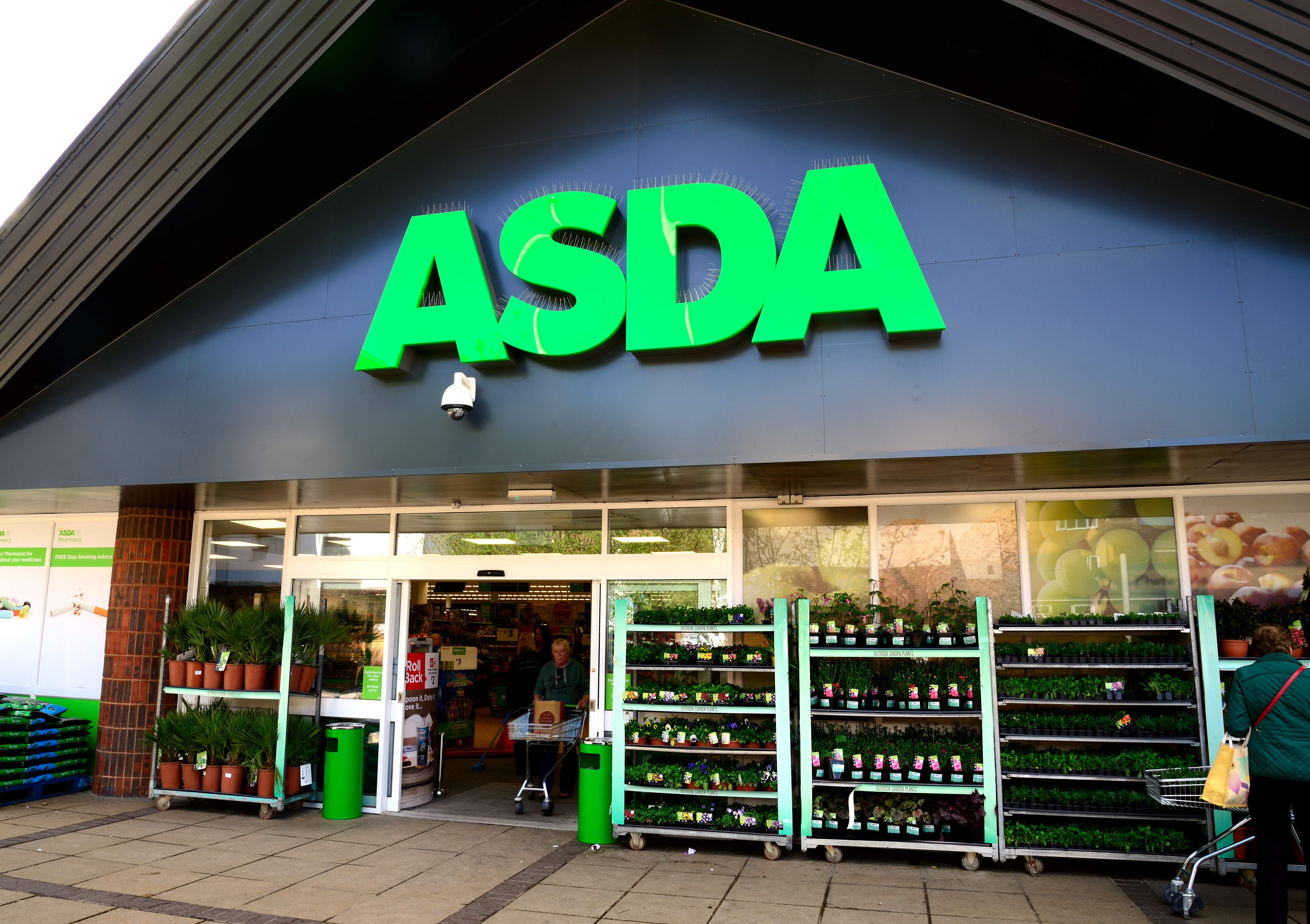 Waterlooville, UK – May 2, 2018: Asda Stores Ltd. trading as Asda, is a British supermarket retailer. The logo is prominent above the glass fronted store-front. Advertising, products and Sshoppers are all visible.
