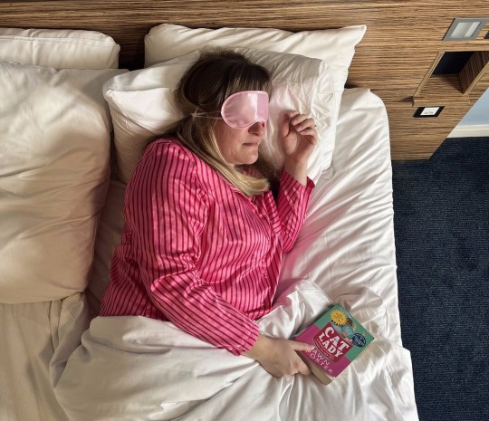 Alison Perry in stripey pink pyjamas sleeps in bed wearing an eye mask 