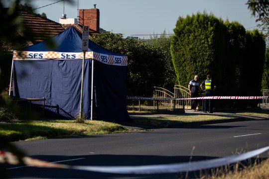 A member of Victoria Police speaks with a resident after the discovery of a man's body on Albert Street in the suburb of Preston in Melbourne, Monday, March 18, 2024. A man has plummeted to his death from a hot air balloon in suburban Melbourne. (AAP Image/Diego Fedele) NO ARCHIVING