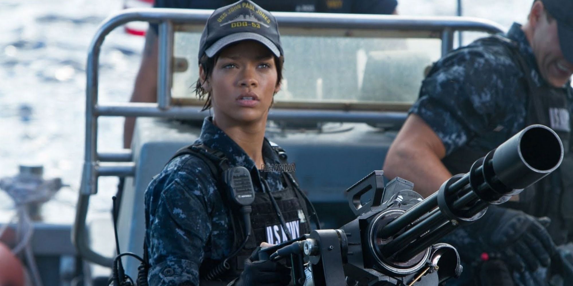 Cora Riakes standing next to a gun looking to the distance in Battleship