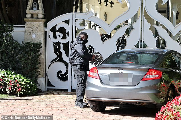 Diddy's home in Star Island security stand watch over the gates that look like they where damaged in yesterday's raid