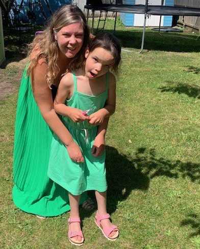 Kate Skelton with Annabelle, both wearing green dresses, outside on the grass
