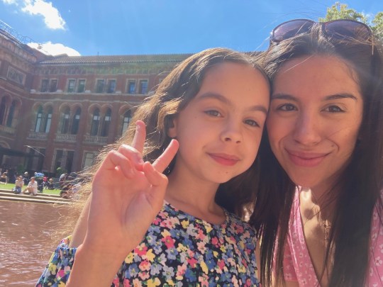 Angela with her daughter, who is doing a peace sign