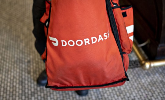 A DoorDash Inc. delivery person holds an insulated bag at Chef Geoff's restaurant in Washington, D.C.