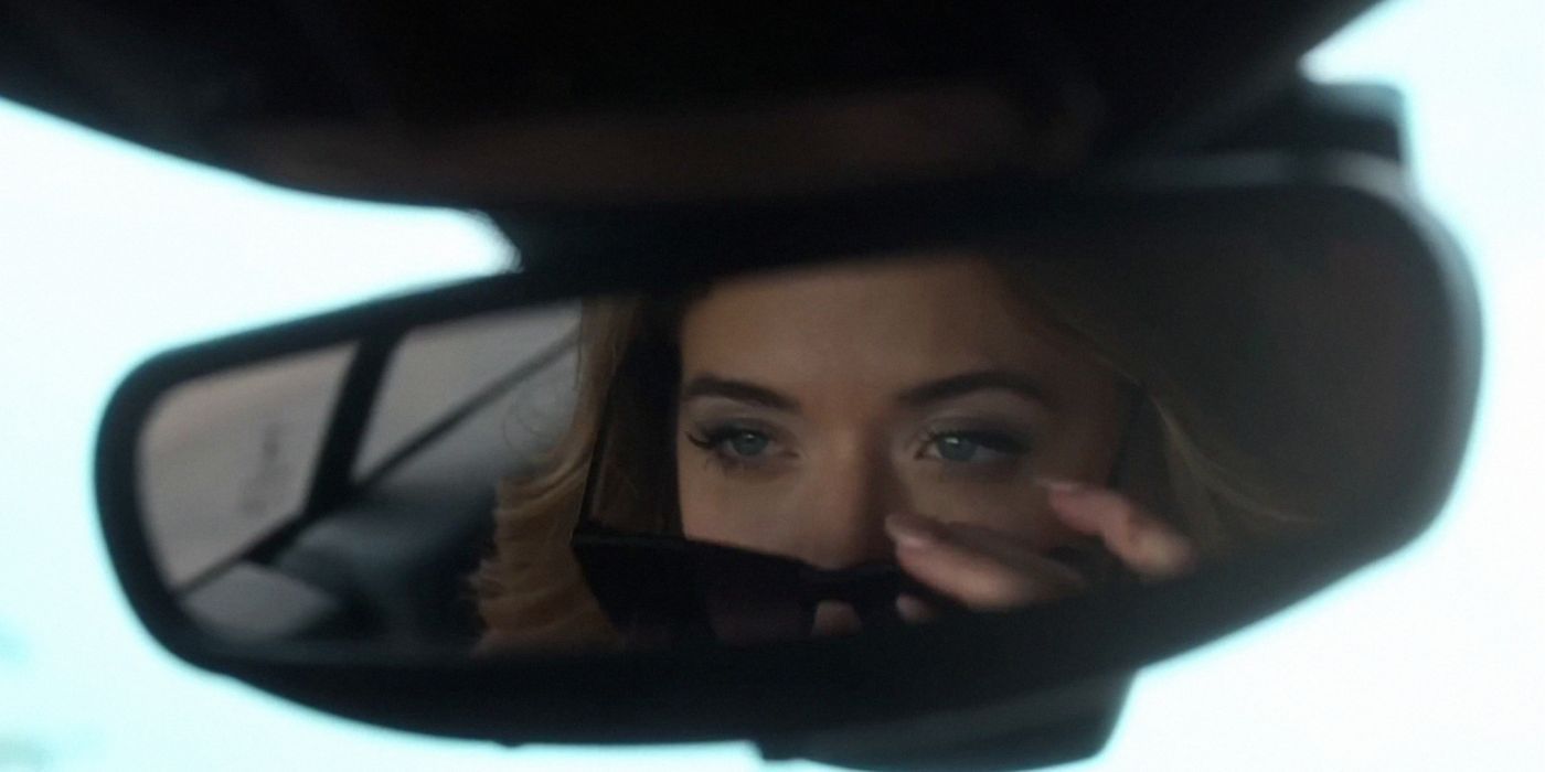 Shot of Sasha Pieterse's reflection in a rearview mirror as she takes off sunglasses from her face.