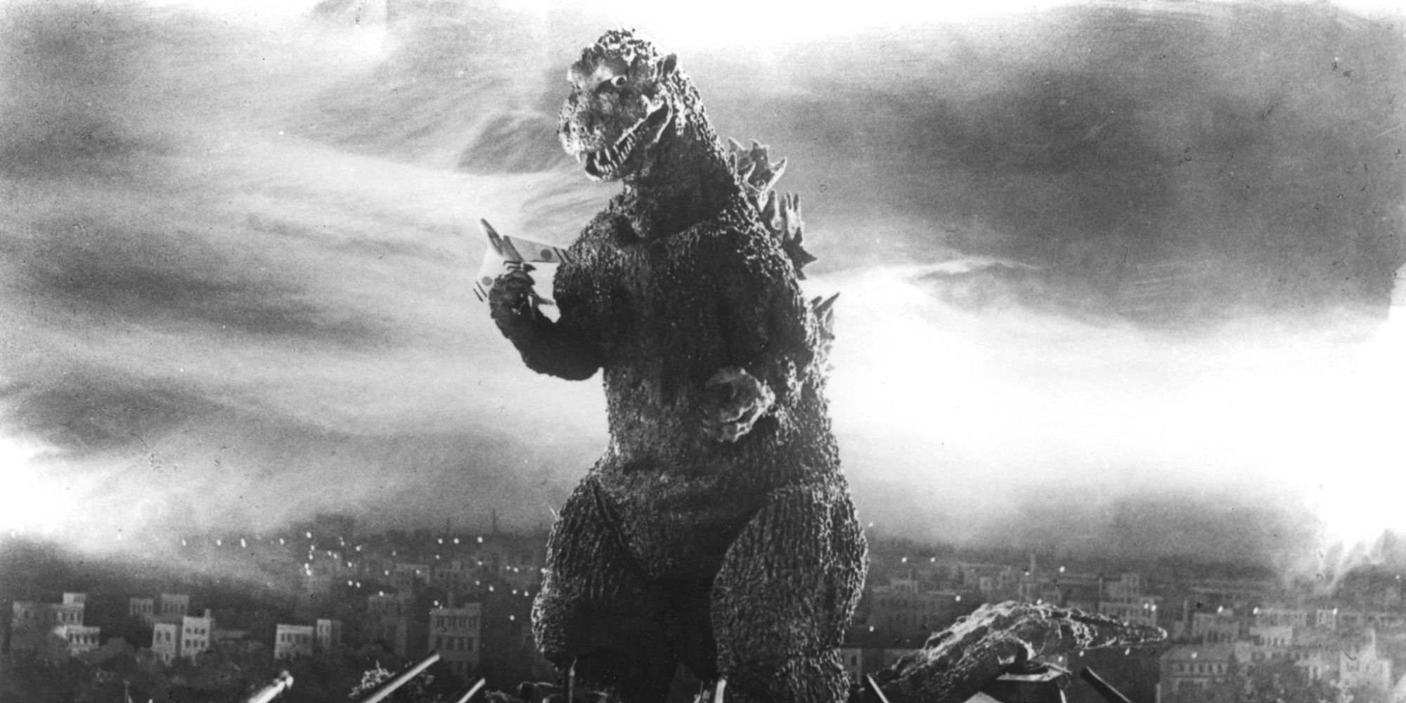 The giant Godzilla standing while holding a plane in Godzilla