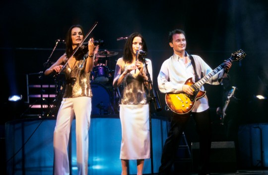 Sharon Corr, Andrea Corr and Jim Corr perform together onstage in the 1990s
