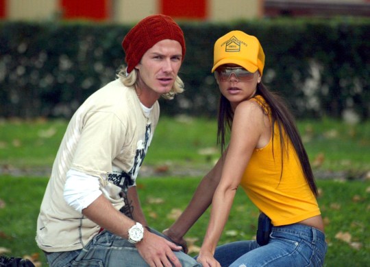 David and Victoria Beckham sitting together on grass