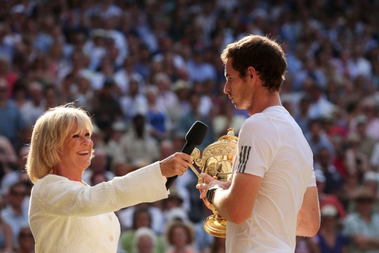 Andy Murray of Great Britain speaks with Sue Barker as he holds the Gentlemen's Singles Trophy
