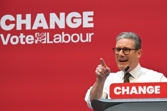 Keir Starmer speaking at the Labour Party manifesto launch. He stands in front of a red background that reads, 'Change, vote Labour'