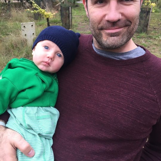 Rob Delaney holds his young son, Henry as they stand outside