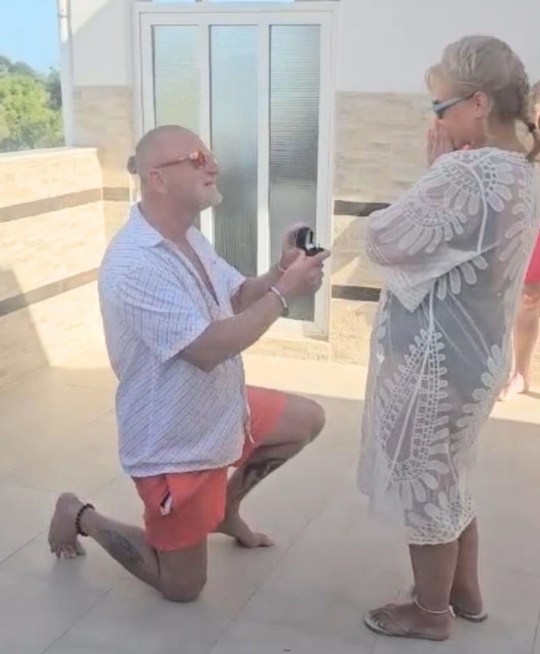 PIC FROM Kennedy News and Media (PIC SHOWS: GARETH WILLIAMS, 60, PROPOSING TO PARTNER LOUISE WALKINGTON, 56, ON HOLIDAY IN CORFU) A holidaymaker thought her new fiance was about to die in her arms - when he collapsed on the dancefloor after popping the question during a romantic holiday. Louise Walkington, who lives in Sittingbourne, Kent, was holidaying with her partner Gareth Williams in Kavos, Corfu, earlier this month when he made a shock marriage proposal a few days into the trip. Gareth - a 60-year-old former housing company foreman - decided to pop the question in the same resort where the pair had met the year before while on holiday. DISCLAIMER: While Kennedy News and Media uses its best endeavours to establish the copyright and authenticity of all pictures supplied, it accepts no liability for any damage, loss or legal action caused by the use of images supplied and the publication of images is solely at your discretion. SEE KENNEDY NEWS COPY - 0161 697 4266