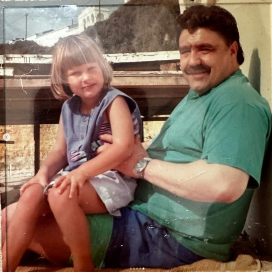 Sophie Hinchliffe as a child sitting on her dad's knee