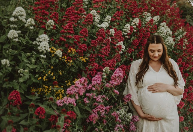 Ruth in a white dress against flowers 