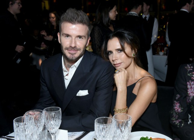 David Beckham and Victoria Beckham sitting together at a table